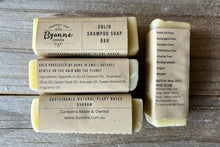 Three solid shampoo bars with Byanne Canberra labels on a wooden surface