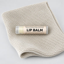Lip balm on a textured beige fabric background